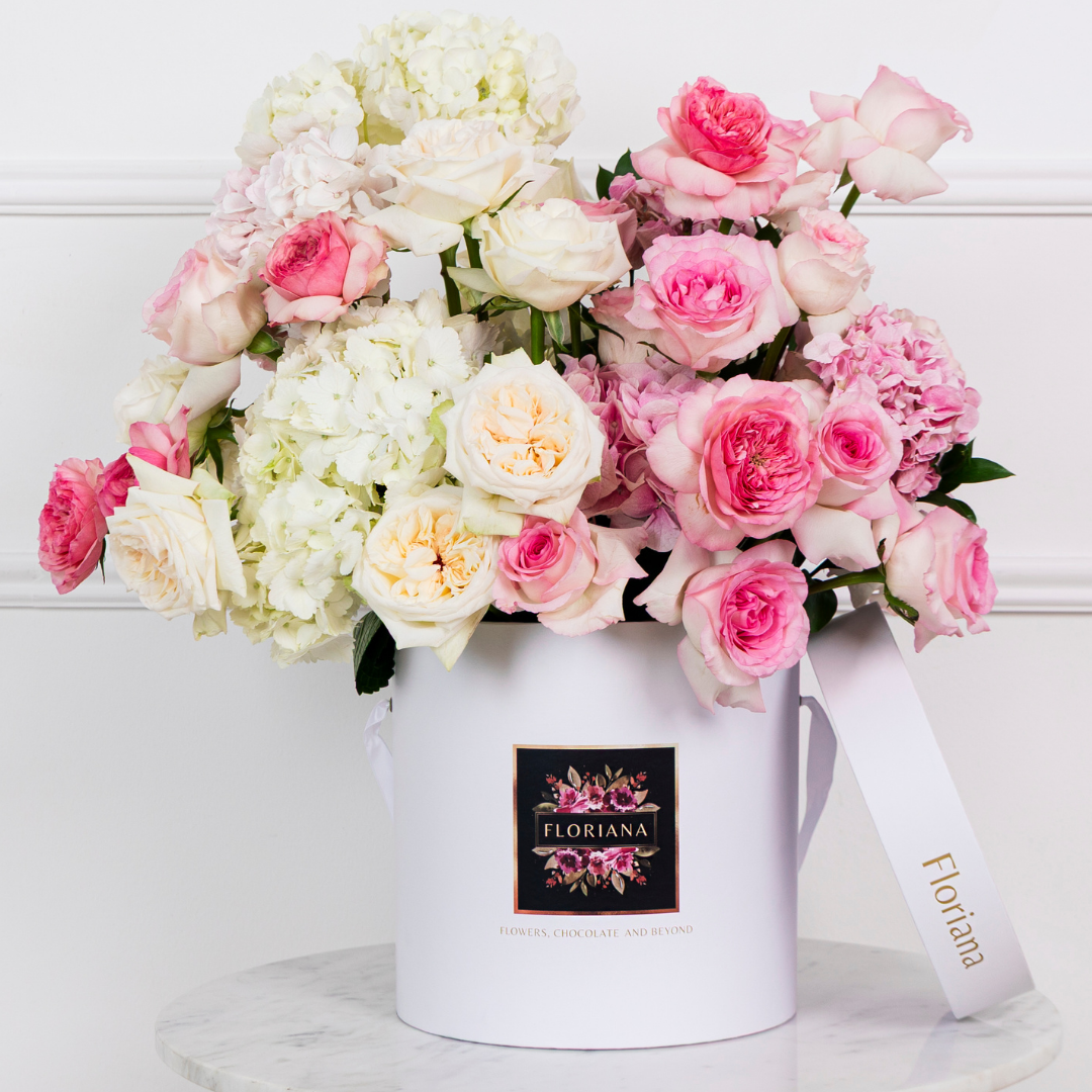 pink and white roses and hydrangeas in round floral box white
